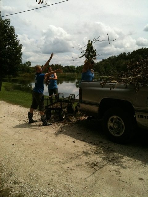 Interns Heave Tree Trimmings into Old Truck