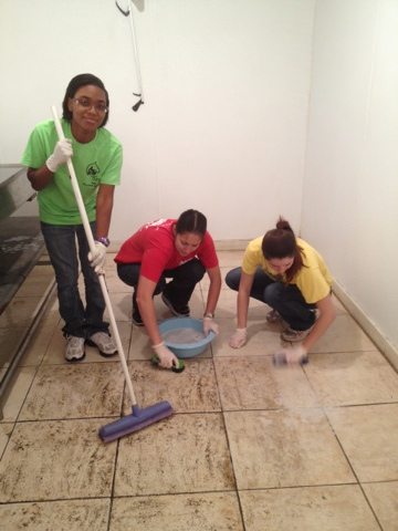 Volunteers and Advocats scrubbing the floor of the cooler