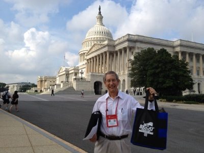 Howard Baskin holds up the conference bag w/ Big Cat Rescue's logo in front of the capitol